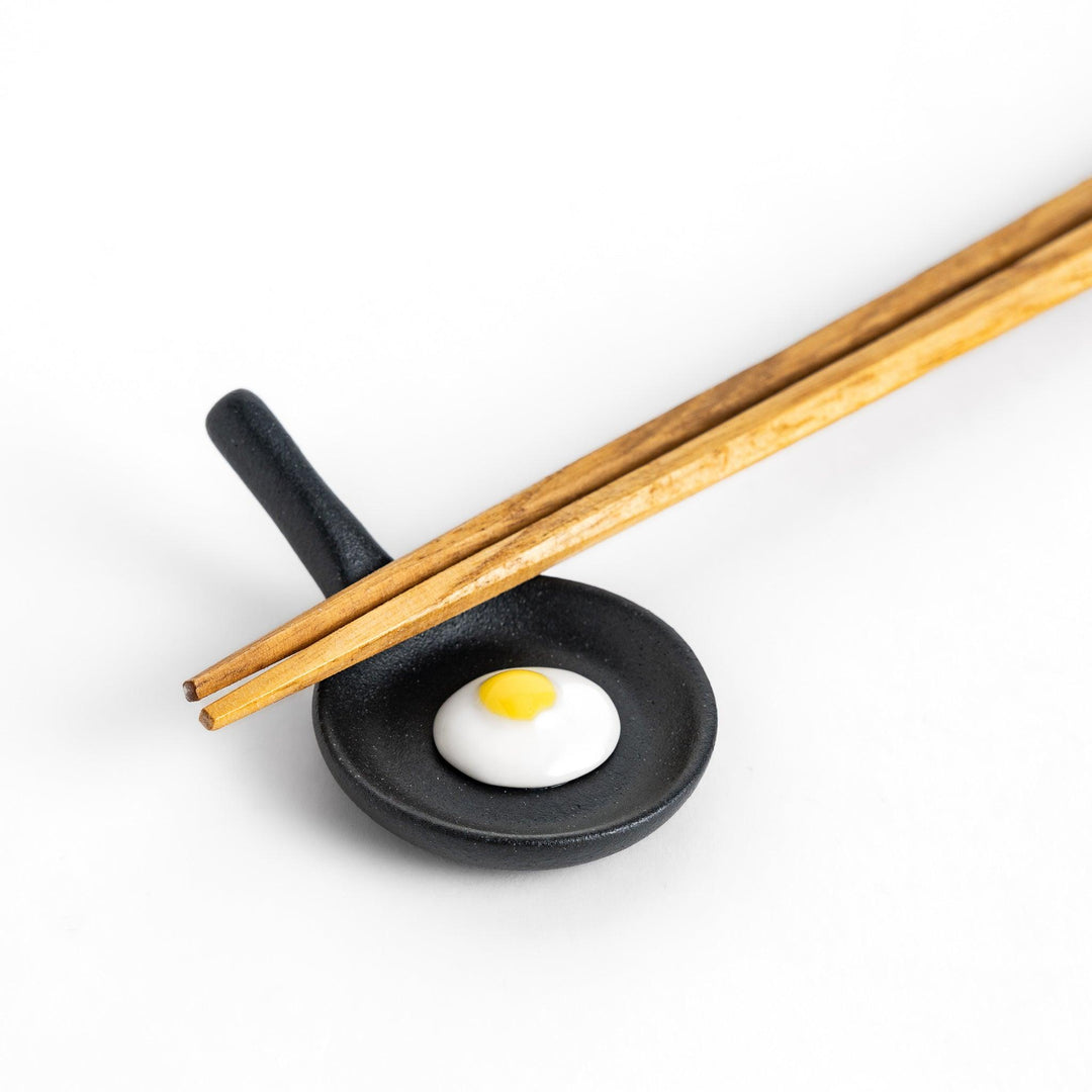 Chopstick rest shaped like a frying pan with a realistic fried egg design, adding a fun and playful touch to your dining experience.