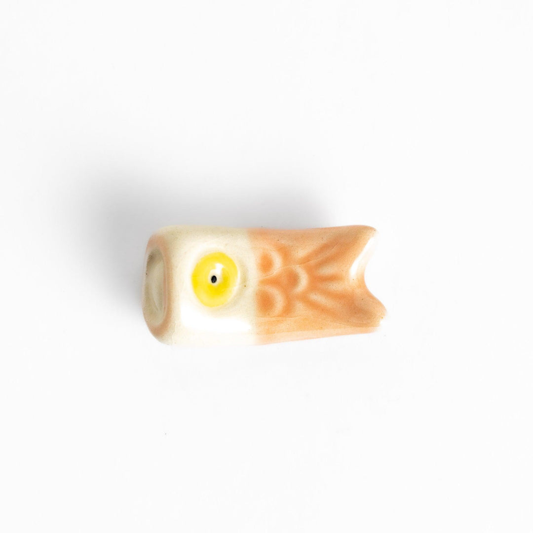 Peach carp streamer chopstick rest with a playful yellow eye design.