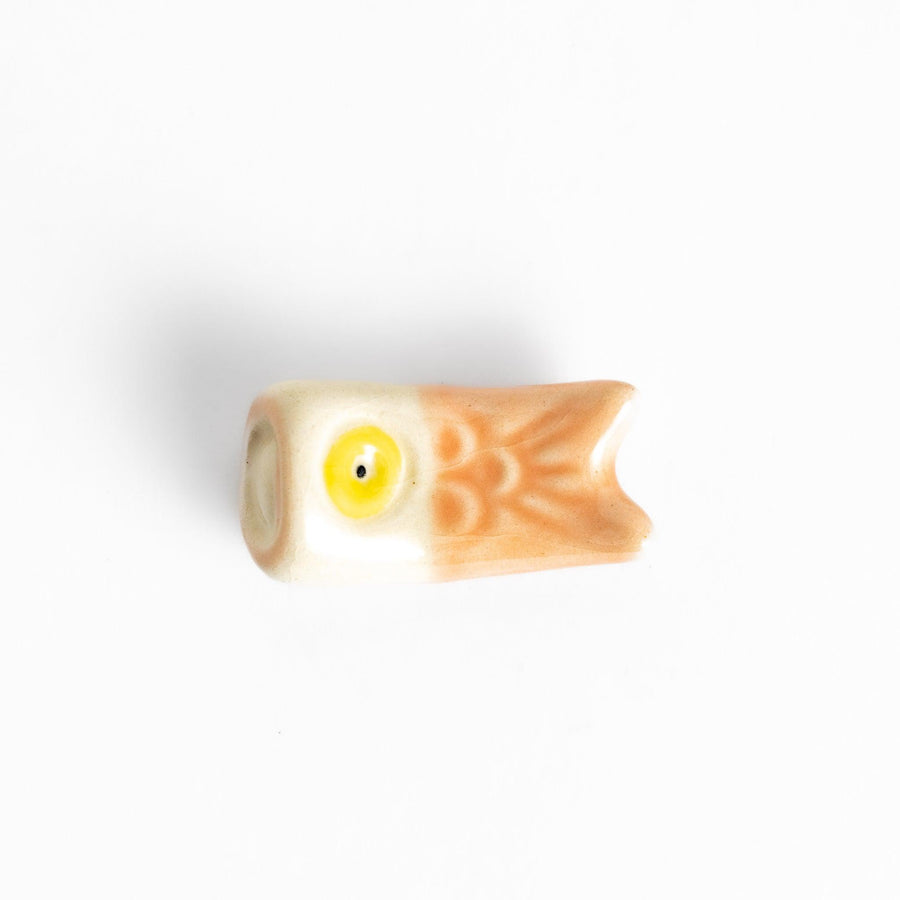 Peach carp streamer chopstick rest with a playful yellow eye design.