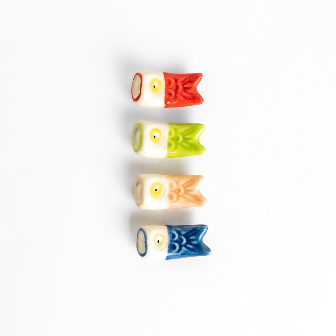 Set of four colorful carp streamers chopstick rests in red, green, pink, and blue, each with a playful yellow eye design.