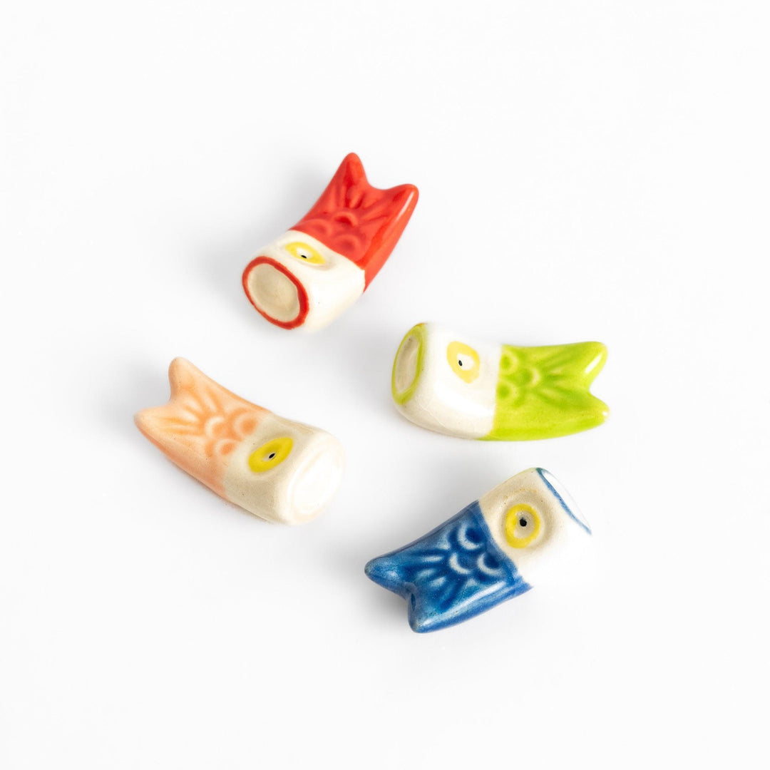 Set of four colorful carp streamers chopstick rests in red, green, pink, and blue, each with a playful yellow eye design.