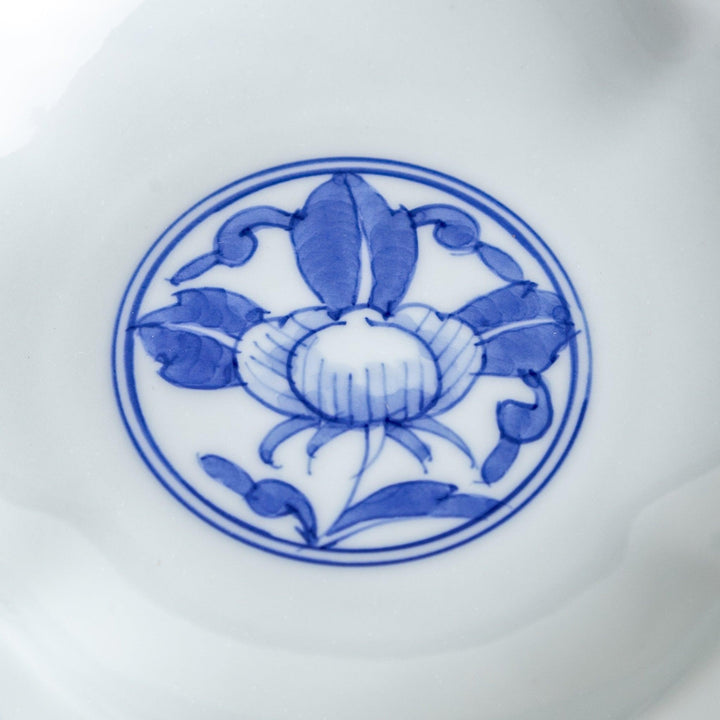 A blue and white porcelain dish with a floral motif in the center, shaped like a cloud.