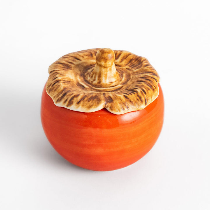 Persimmon Lidded Condiment Bowl, a ceramic bowl with a glossy orange finish and a detailed lid shaped like a persimmon leaf, perfect for serving sauces and condiments.