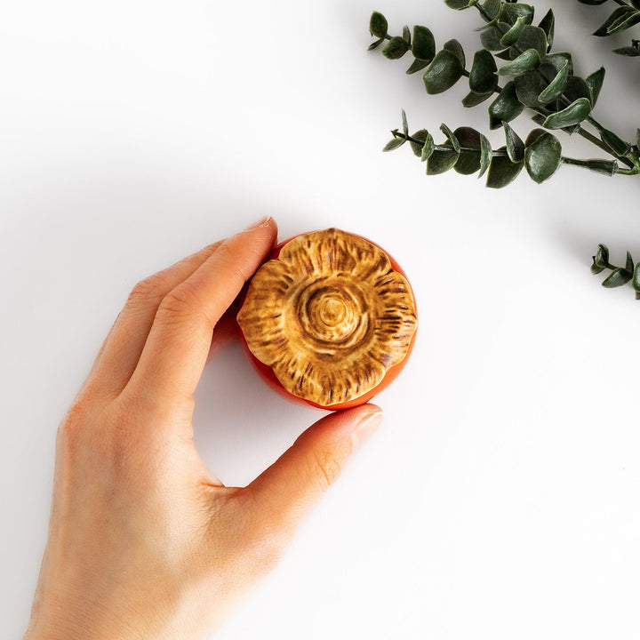 Persimmon Lidded Condiment Bowl, a ceramic bowl with a glossy orange finish and a detailed lid shaped like a persimmon leaf, perfect for serving sauces and condiments.