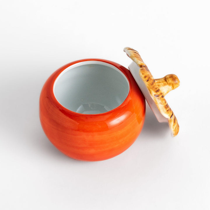 Persimmon Lidded Condiment Bowl, a ceramic bowl with a glossy orange finish and a detailed lid shaped like a persimmon leaf, perfect for serving sauces and condiments.