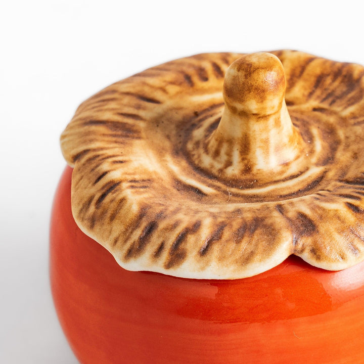 Persimmon Lidded Condiment Bowl, a ceramic bowl with a glossy orange finish and a detailed lid shaped like a persimmon leaf, perfect for serving sauces and condiments.