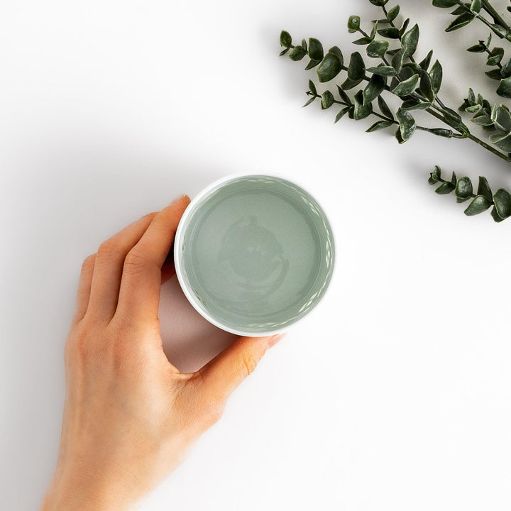 Unique ceramic glass featuring a delicate cut-out floral design, perfect for adding a touch of elegance to any table.