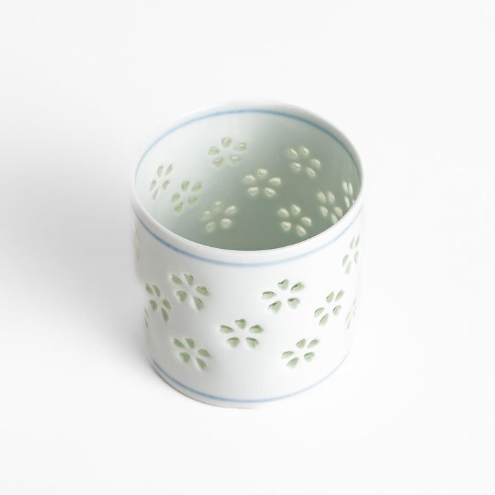Unique ceramic glass featuring a delicate cut-out floral design, perfect for adding a touch of elegance to any table.