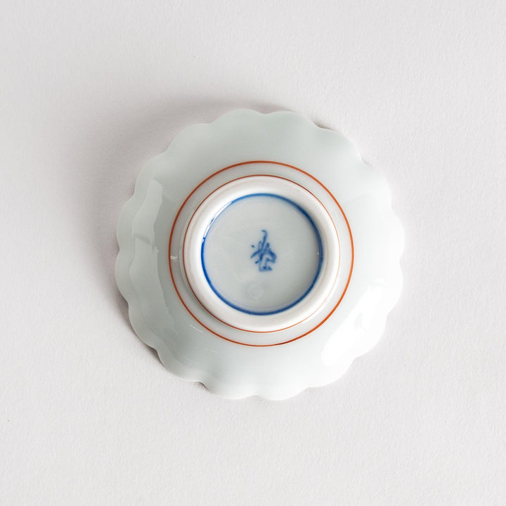 A small round dessert bowl with a delicate blue chrysanthemum pattern and scalloped edges.