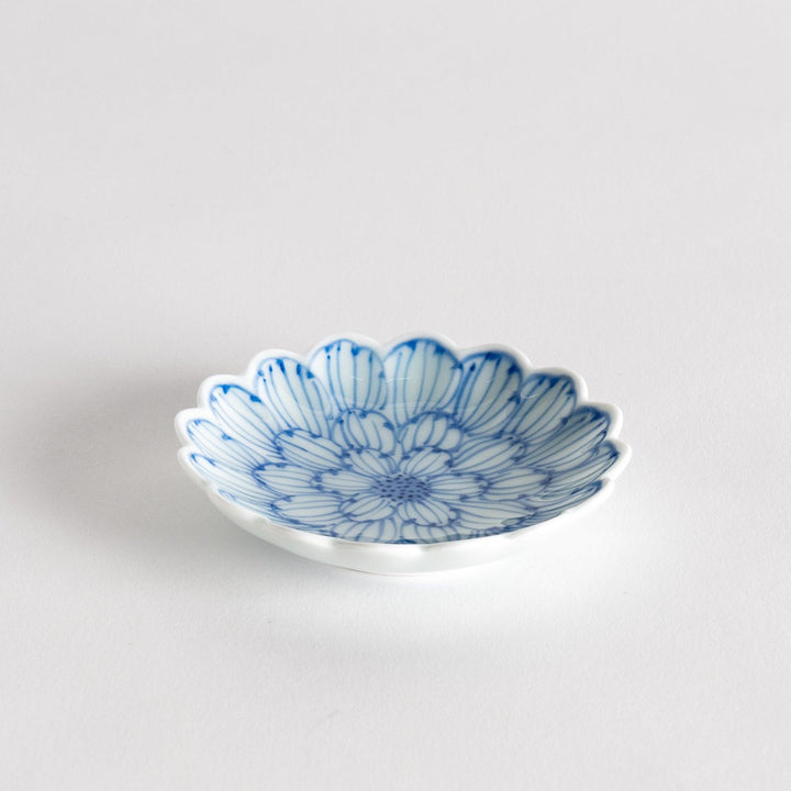 A small round dessert bowl with a delicate blue chrysanthemum pattern and scalloped edges.