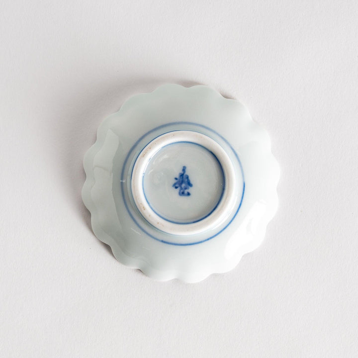 A small round dessert bowl with a delicate blue chrysanthemum pattern and scalloped edges.