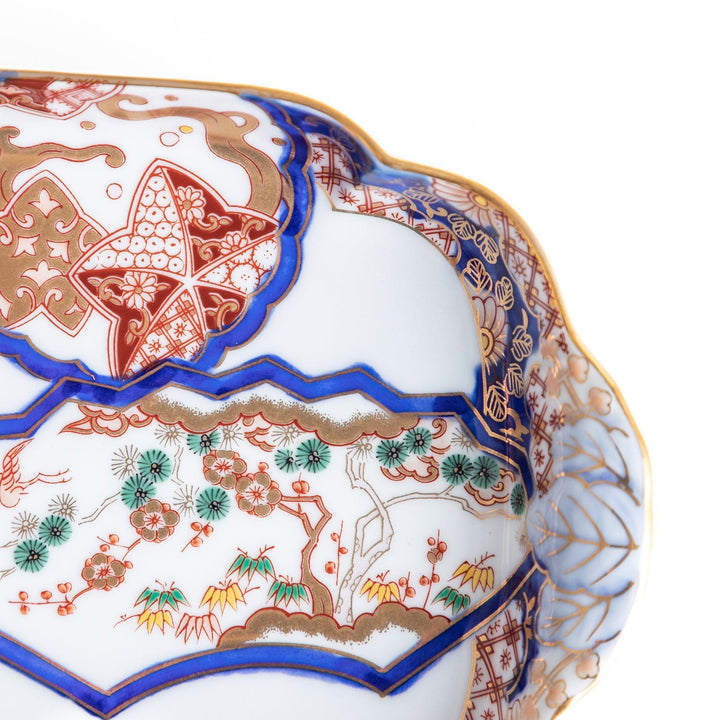 A rectangular salad plate with handles, decorated with scenes of cranes and trees in a traditional Japanese style, bordered by intricate red, blue, and gold patterns.