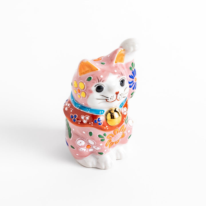 Charming pink blossom Maneki Neko figurine, adorned with colorful floral patterns and a golden bell, symbolizing good luck and prosperity with a cheerful waving gesture.