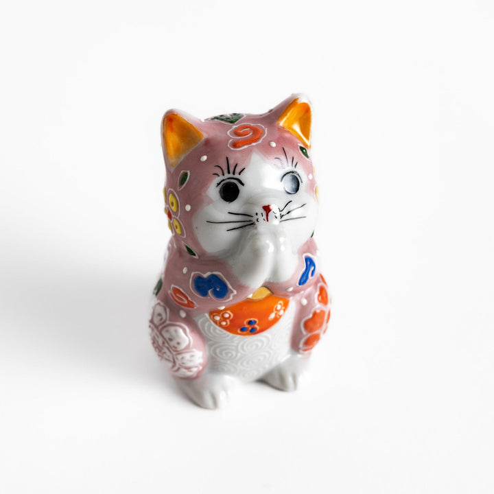 Maneki Neko figurine featuring a pink blossom design with vibrant colors and a praying posture for good fortune.