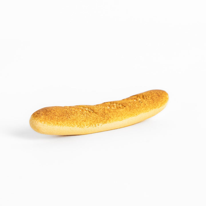 Plain baguette-shaped chopstick rest with a simple, elegant design, featuring detailed imprints resembling the crust of a baguette.
