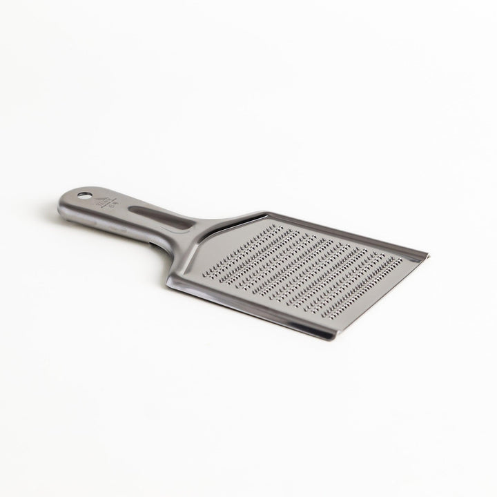 Durable stainless steel grater with sharp blades and an ergonomic handle, a versatile kitchenware tool for grating cheese, vegetables, and spices.