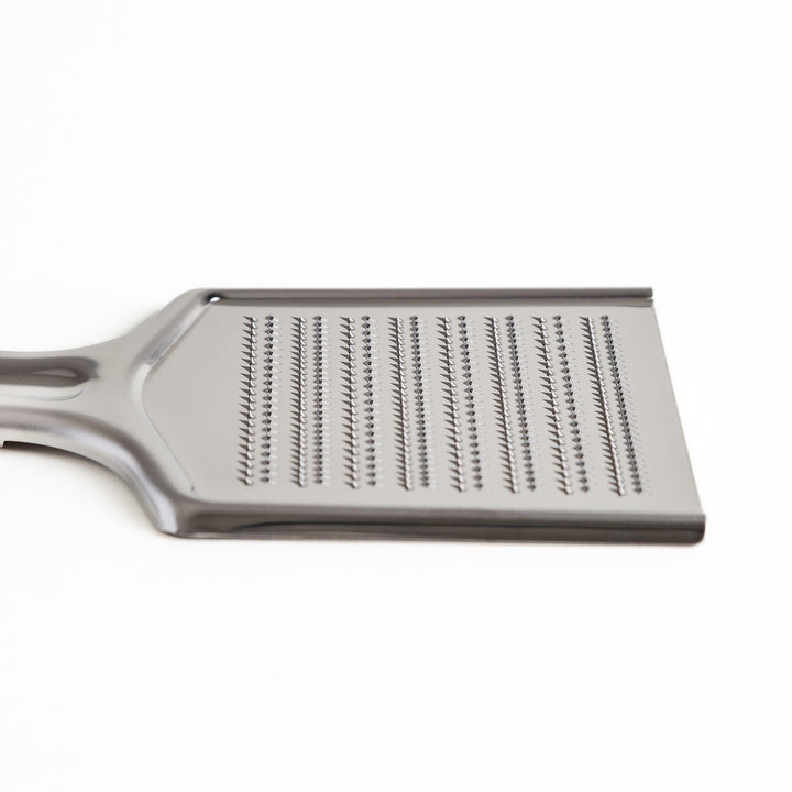Durable stainless steel grater with sharp blades and an ergonomic handle, a versatile kitchenware tool for grating cheese, vegetables, and spices.