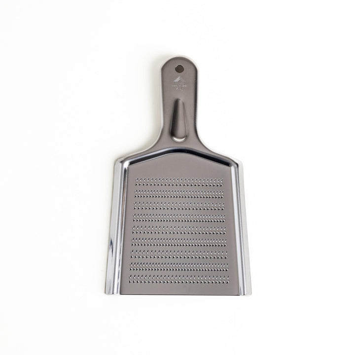 Durable stainless steel grater with sharp blades on both sides, a versatile kitchenware tool for efficiently grating vegetables, cheese, and other ingredients.