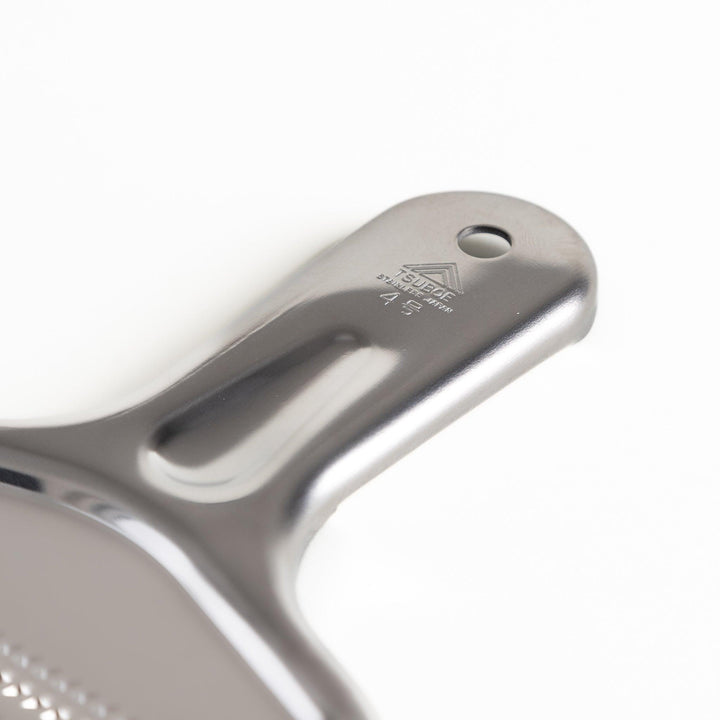 Durable stainless steel grater with sharp blades on both sides, a versatile kitchenware tool for efficiently grating vegetables, cheese, and other ingredients.