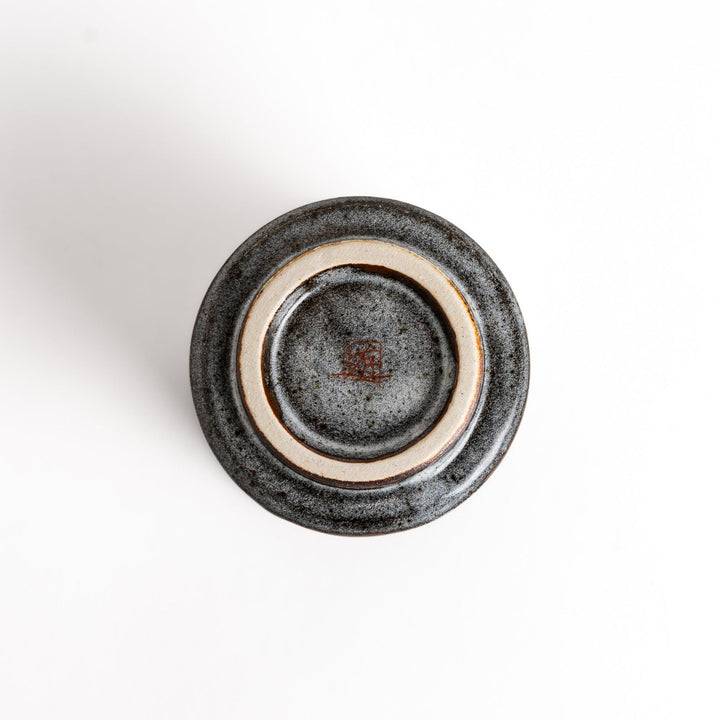 Charming ceramic teacup featuring two cats gazing at small flowers, with a unique speckled glaze and a comfortable shape for holding.