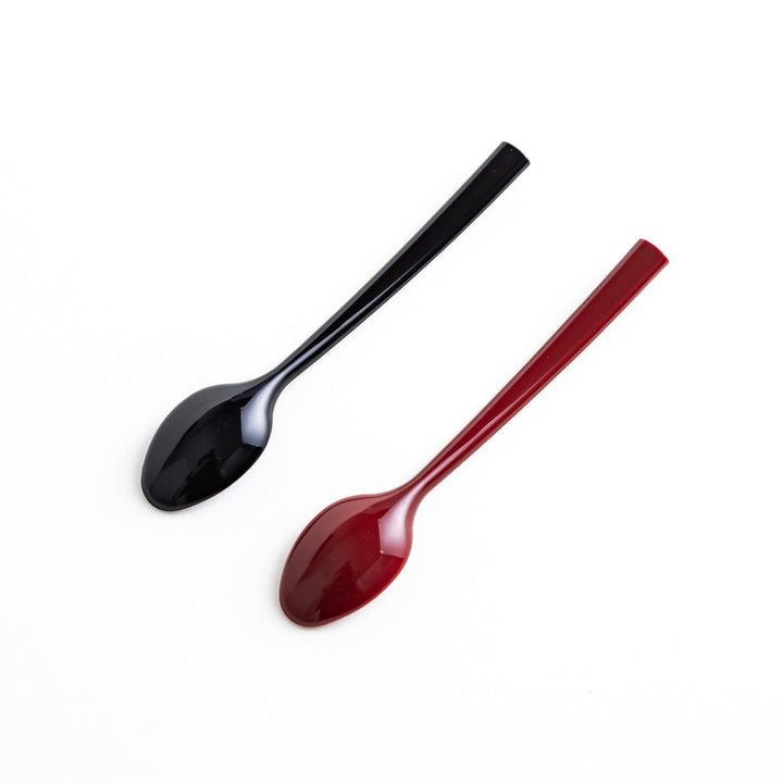 A set of two coffee spoons, one red and one black, with gold floral designs on the handles.