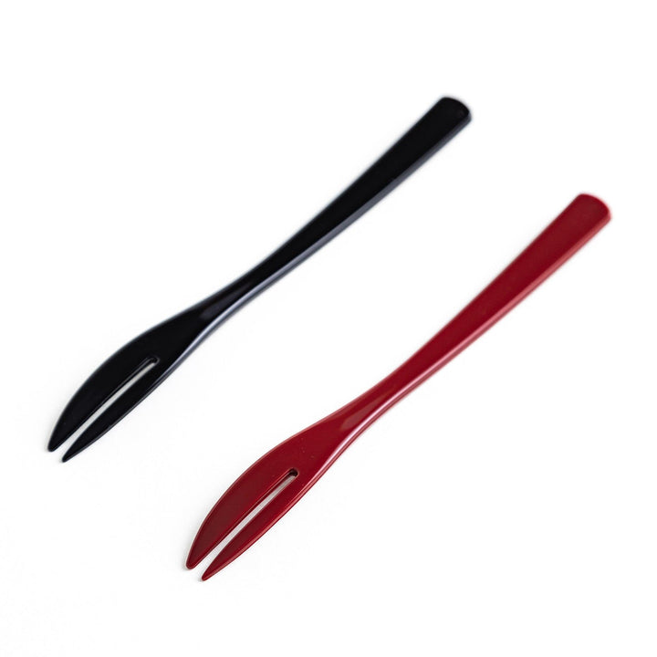 A set of two dessert forks, one red and one black, with rabbit designs on the handles.