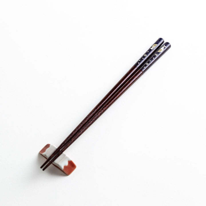 A pair of lacquered chopsticks adorned with floral patterns and rabbit. Available in purple or red.