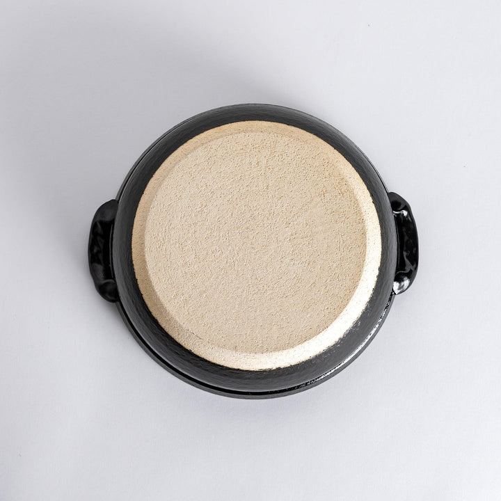 A 8-inch donabe with a vibrant red blossom pattern lid and black pot.