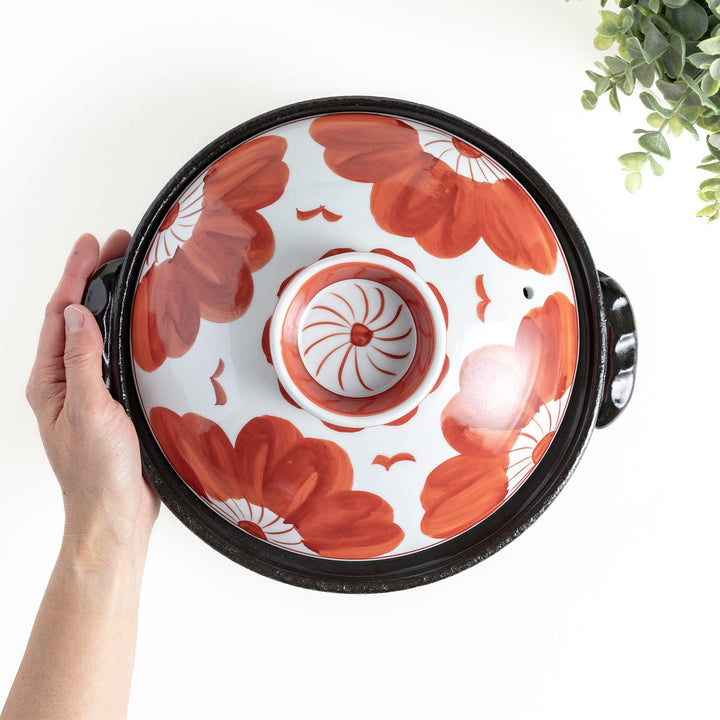 A 8-inch donabe with a vibrant black floral pattern lid and black pot.