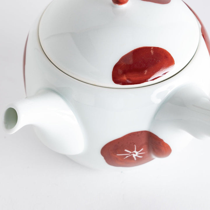 Close-up of the teapot's spout and lid, emphasizing the artistic red detailing and overall craftsmanship.