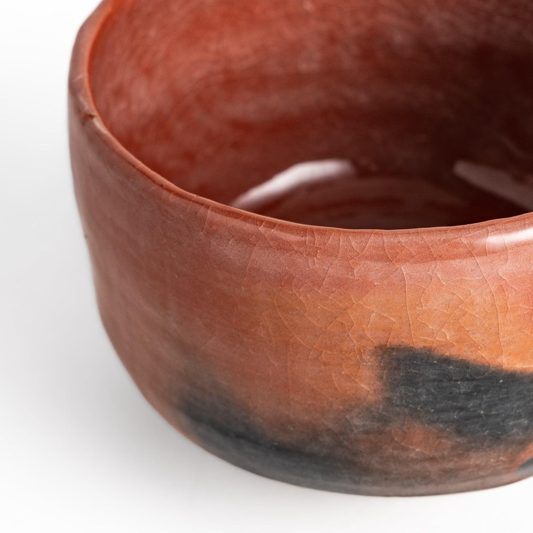 Rustic Raku ware Matcha bowl with a unique textured glaze and a striking black and red design.
