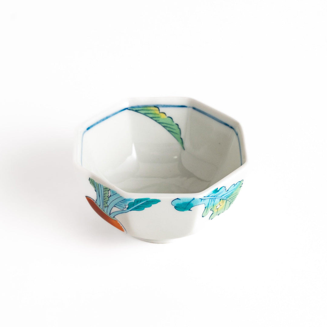A white porcelain dessert bowl adorned with vibrant illustrations of red turnips and green leaves. Its octagonal shape adds elegance.
