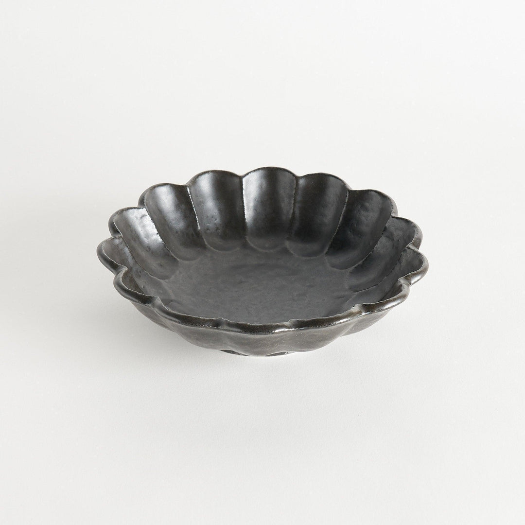 A white ceramic pasta bowl with a scalloped flower-petal design.