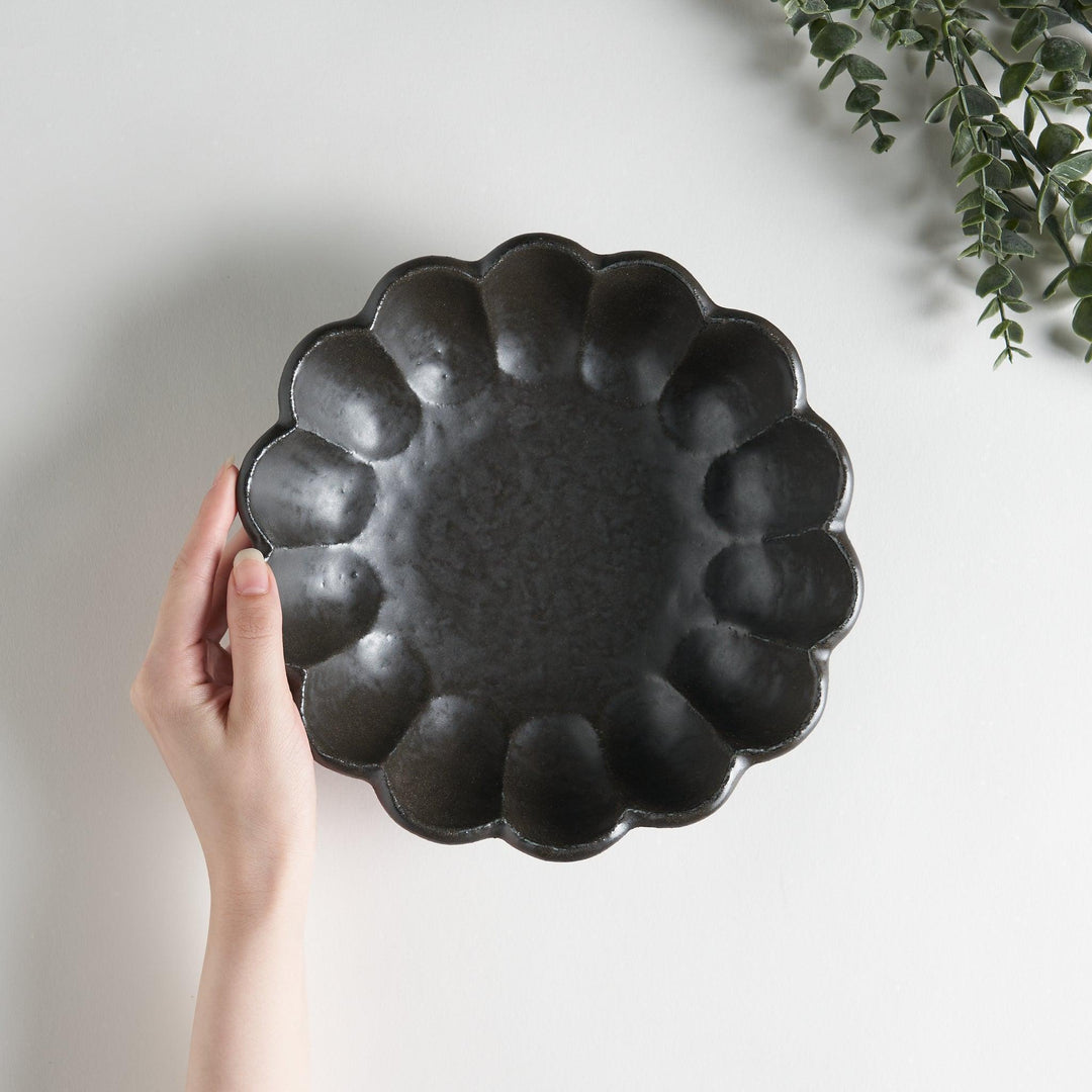 A white ceramic pasta bowl with a scalloped flower-petal design.