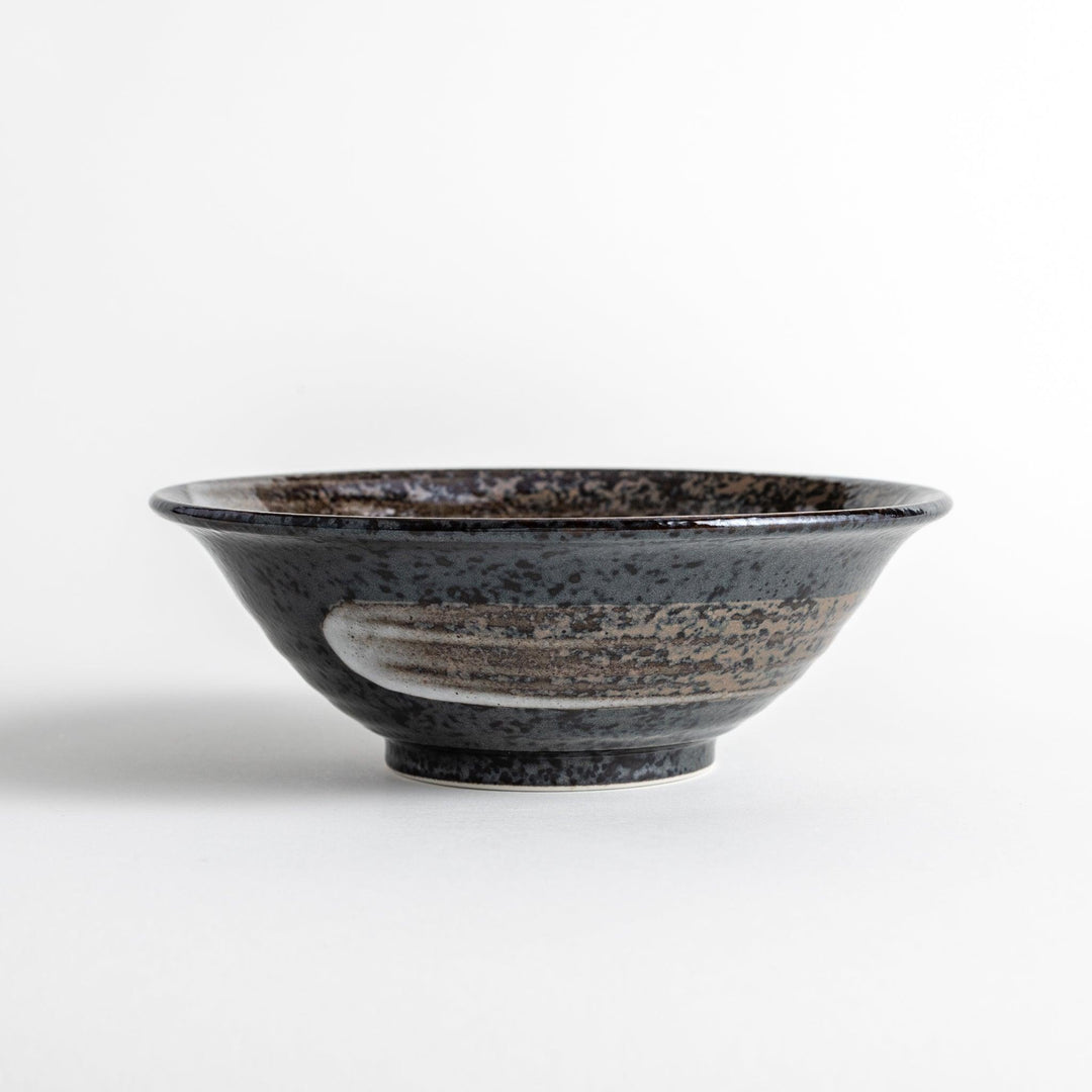 A deep ceramic bowl with a glossy black glaze and irregular brown and speckles.