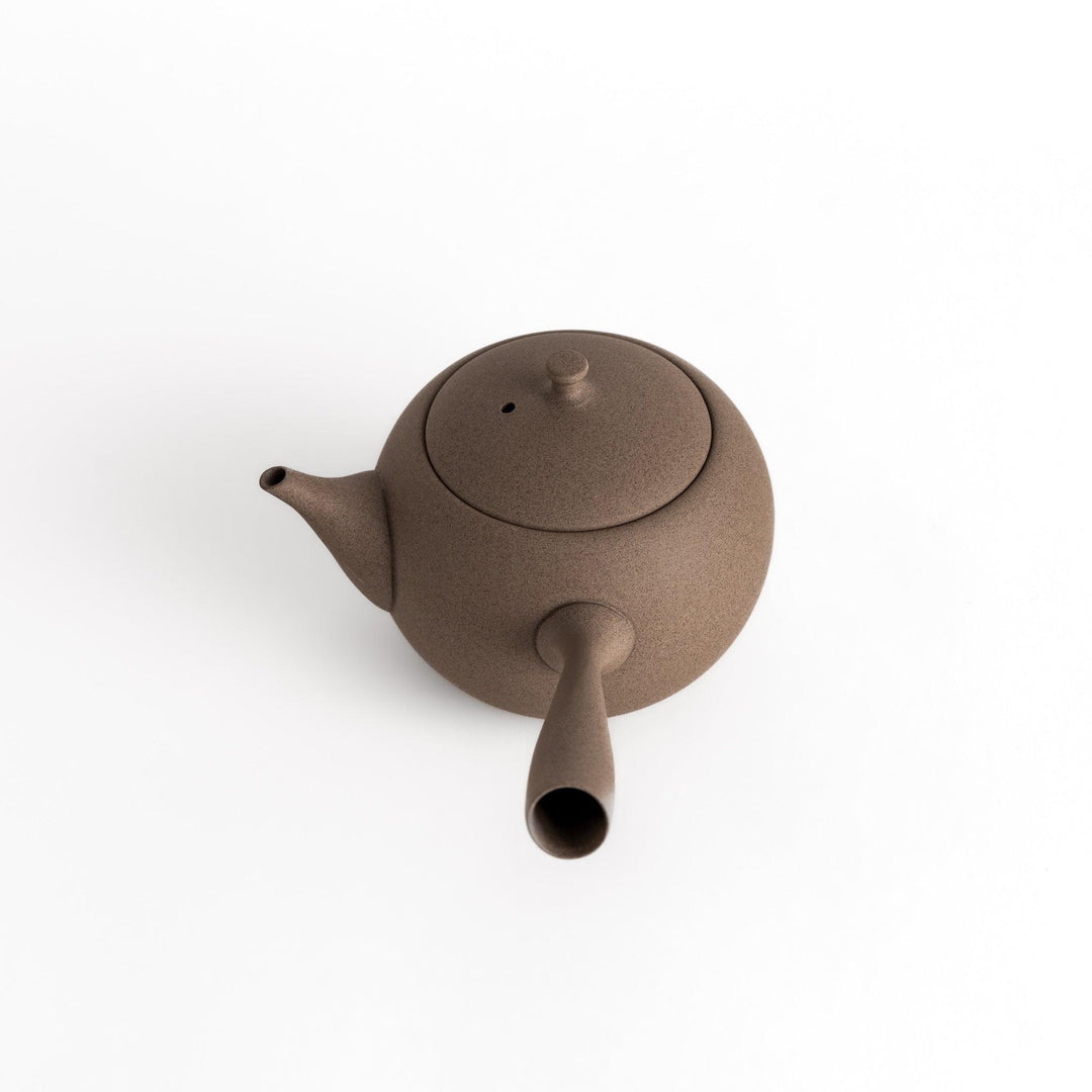 Angled view of the gray teapot highlighting its textured surface and smooth, rounded form.