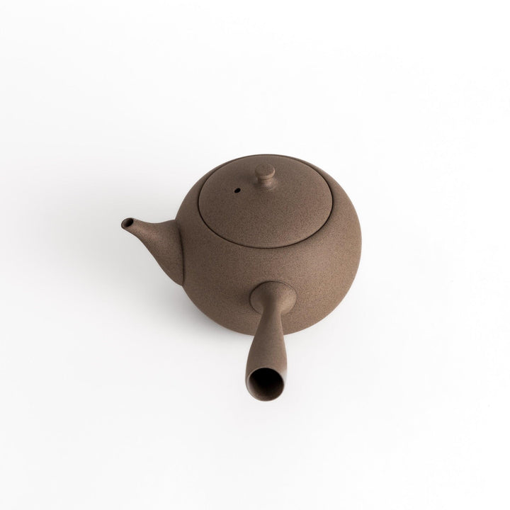Angled view of the gray teapot highlighting its textured surface and smooth, rounded form.
