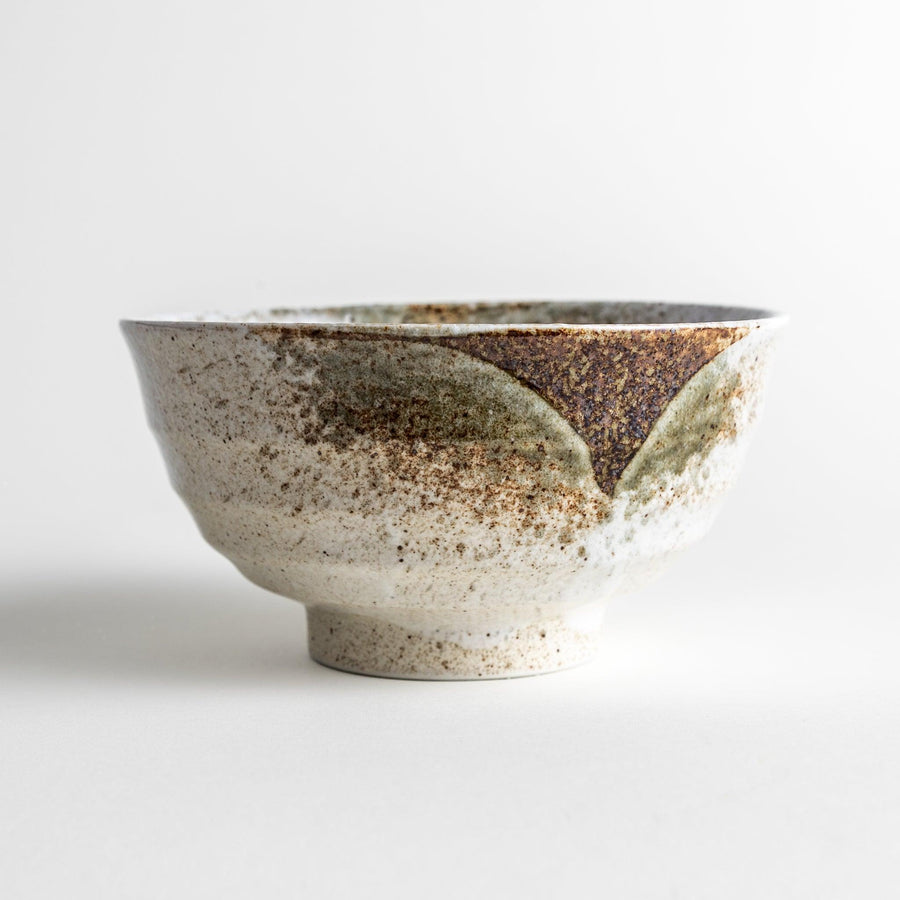 A ceramic bowl with a speckled cream and brown glaze, showcasing an earthy and organic finish.