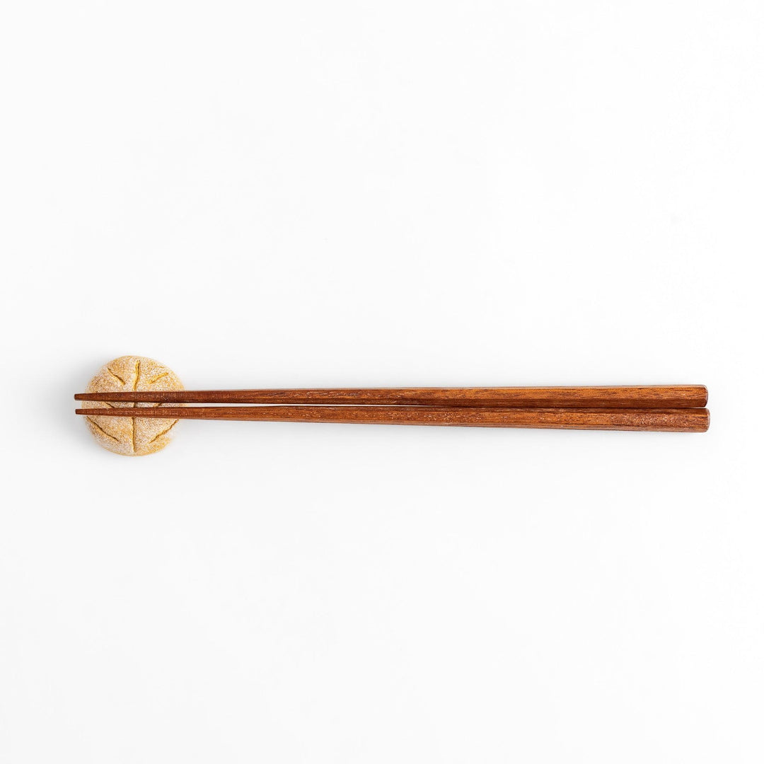 Rustic bread-shaped chopstick rest, featuring a natural, earthy design with a leaf-like scoring on top.