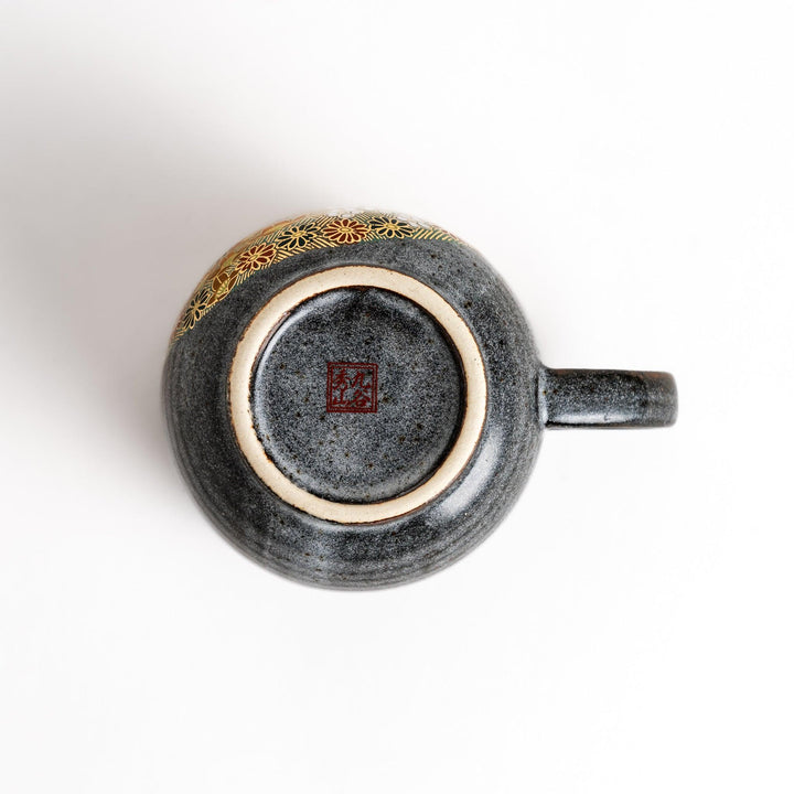 Gray ceramic mug with a vibrant floral pattern in gold and pastel colors, featuring a comfortable handle and a unique speckled glaze.