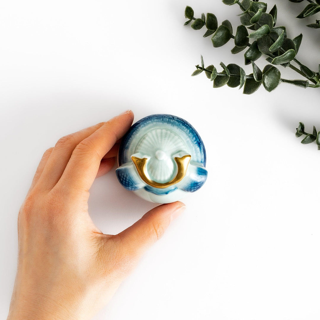 Samurai Helmet Lidded Condiment Bowl, a ceramic bowl with a unique lid shaped like a samurai helmet, featuring intricate blue and gold detailing, perfect for serving sauces.