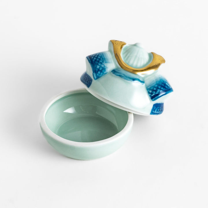 Samurai Helmet Lidded Condiment Bowl, a ceramic bowl with a unique lid shaped like a samurai helmet, featuring intricate blue and gold detailing, perfect for serving sauces.