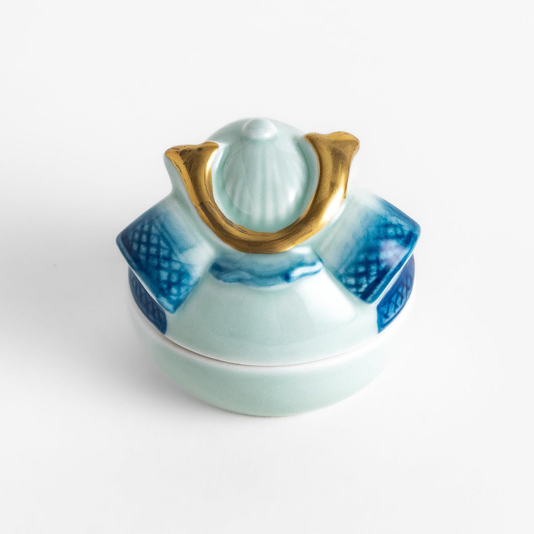 Samurai Helmet Lidded Condiment Bowl, a ceramic bowl with a unique lid shaped like a samurai helmet, featuring intricate blue and gold detailing, perfect for serving sauces.