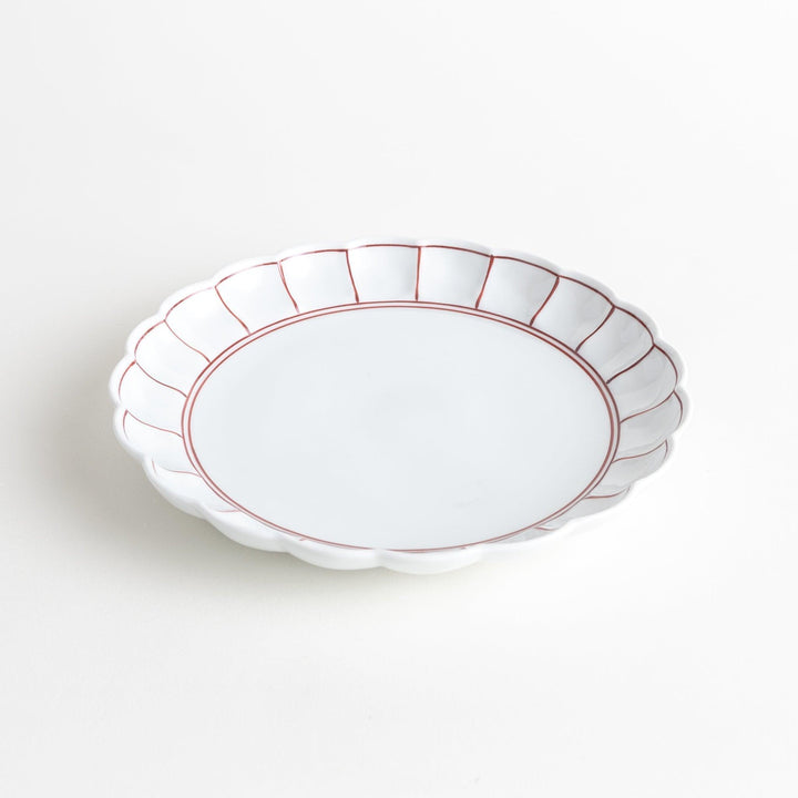 White salad plate with scalloped edges, outlined in a thin blue or red line.