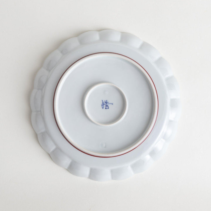 White salad plate with scalloped edges, outlined in a thin blue or red line.