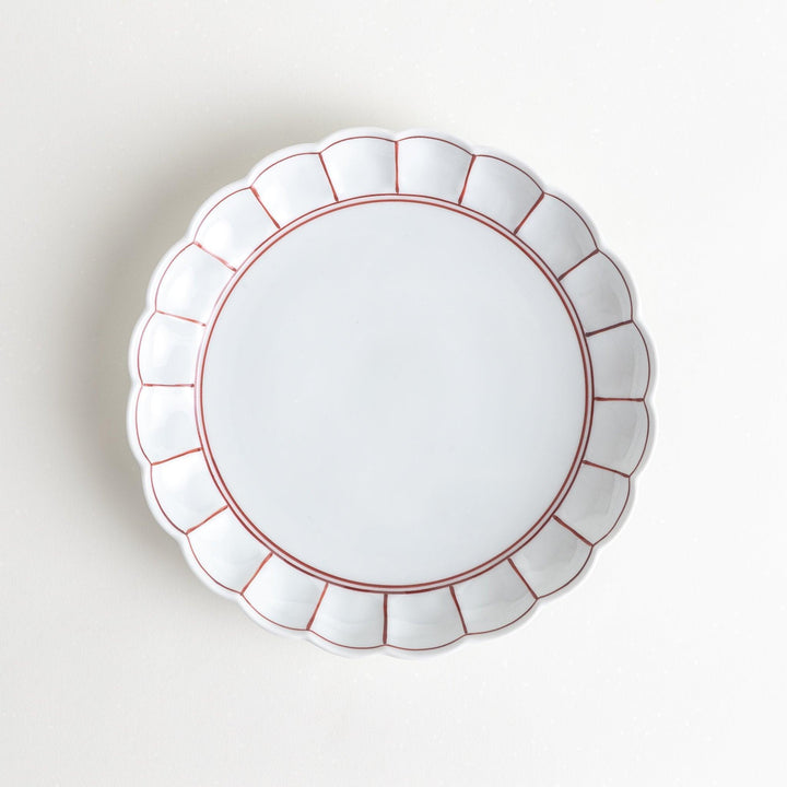 White salad plate with scalloped edges, outlined in a thin blue or red line.