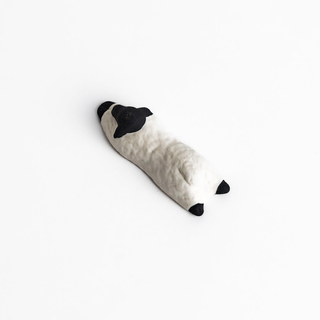 Adorable sleeping sheep chopstick rest, crafted with a minimalist design in black and white, adding a playful and charming touch to your dining table.