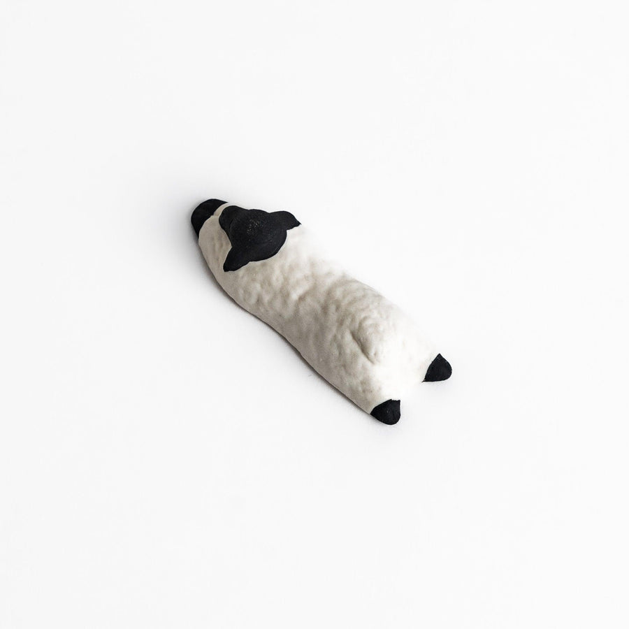 Adorable sleeping sheep chopstick rest, crafted with a minimalist design in black and white, adding a playful and charming touch to your dining table.