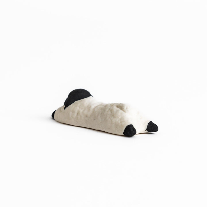 Adorable sleeping sheep chopstick rest, crafted with a minimalist design in black and white, adding a playful and charming touch to your dining table.