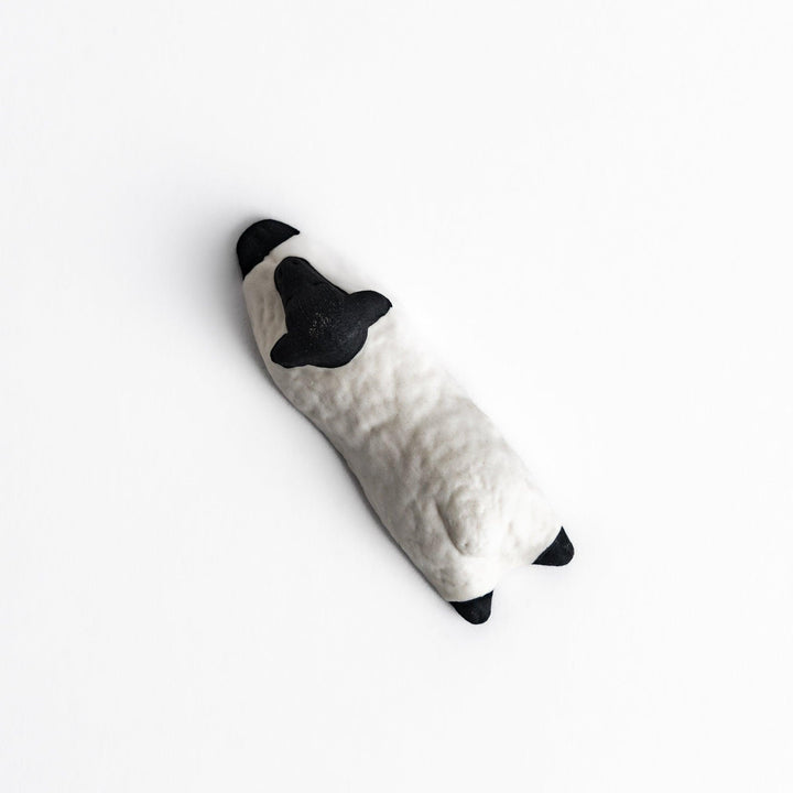 Adorable sleeping sheep chopstick rest, crafted with a minimalist design in black and white, adding a playful and charming touch to your dining table.